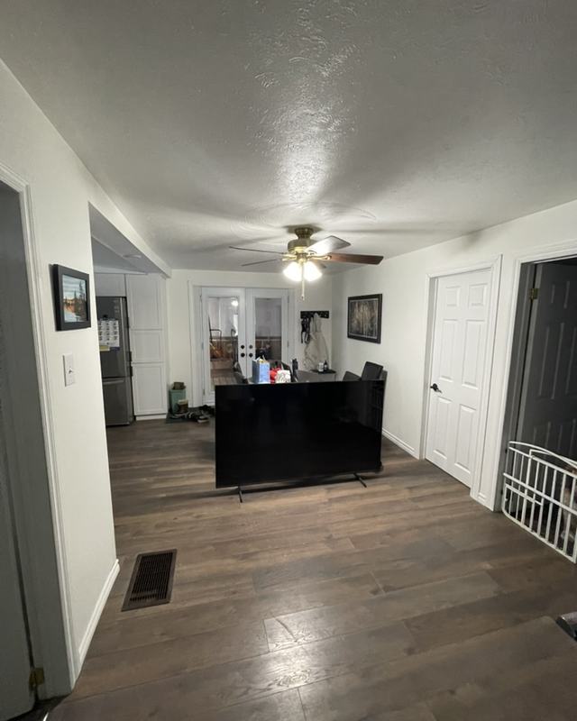 Bungalow living and dining area after painting, white walls and ceiling, dark wood-look flooring