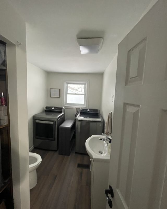 Laundry room after painting with white walls, washer and dryer, pedestal sink and white door