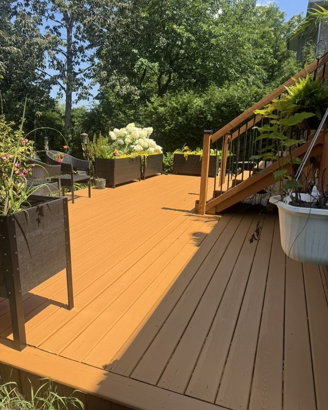 Stained deck walkway in a warm cedar tone leading to garden stairs, planters and hydrangeas alongside